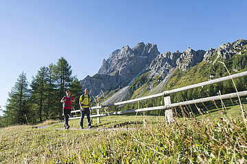 Ein Paar geht einen Wanderweg unterhalb der Dolomiten entlang