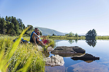 Ein Paar genießt die Sonne an einem glasklaren Bergsee in den Kärntner Nockbergen