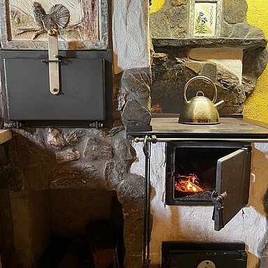 Draußen wird's still, drinnen wird’s gemütlich. Die Wanderschuhe stehen schon in der Ecke, in der Küche klappert das Geschirr und langsam zieht der Duft vom Abendessen durch die ganze Hütte.